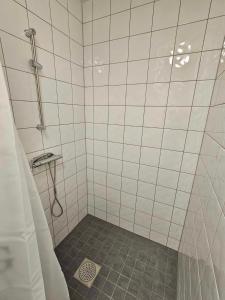 a white tiled shower with a gray floor at Stora Ekeberg vandrarhem in Axvall +115 photos