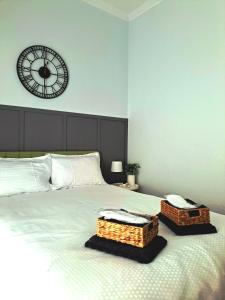 una camera da letto con un grande letto con un orologio sul muro di Stylish City Center Apartment a Serres