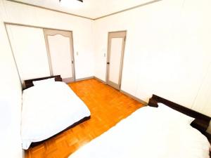 1 Schlafzimmer mit 2 Betten und Holzboden in der Unterkunft Nikko Big House - Max 12 Guests Near Station 2 Parking in Nikko + 18 Fotos