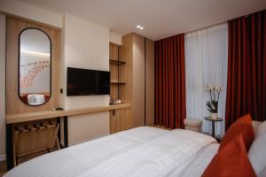 una habitación de hotel con una cama y un espejo en Oro Inn Hotel, en Shkodër