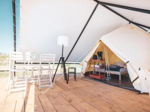 a tent with chairs and a bed in it at Glamping Szelągówka in Sorkwity +41 photos