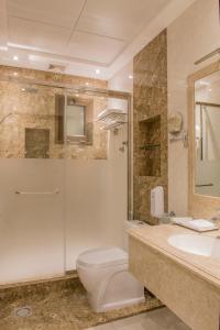uma casa de banho com um WC, um chuveiro e um lavatório. em نور الشرق em Dammam