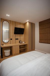 1 dormitorio con 1 cama grande y espejo en Oro Inn Hotel, en Shkodër