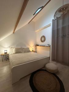 a bedroom with a large bed and a clock on the wall at Les Jardins des 3 sœurs in Quettehou
