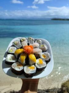 a person holding a plate of food on the beach at Catamaran in San Blás Islands, private boat in Waisalatupo
