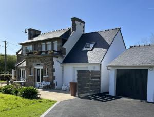een vrijstaand huis met een garage en een oprit bij Vacances de charme entre mer et campagne - Ty Meur in Pleumeur-Bodou