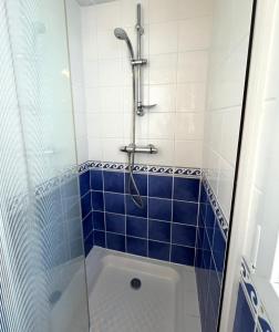een badkamer met een douche met blauwe tegels bij Vacances de charme entre mer et campagne - Ty Meur in Pleumeur-Bodou