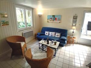 uma sala de estar com um sofá azul e uma mesa em Meschers sur Gironde - MAISON au CALME et en PLEINE NATURE - cœur de la FORET em Meschers-sur-Gironde