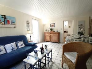 uma sala de estar com um sofá azul e uma mesa em Meschers sur Gironde - MAISON au CALME et en PLEINE NATURE - cœur de la FORET em Meschers-sur-Gironde