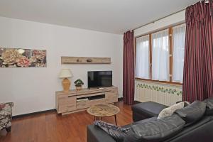 a living room with a couch and a tv at Residence Mimosa PT2 by Wonderful Italy in Toscolano Maderno