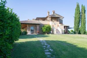 a large house with a green lawn in front of it at Agriturismo Poggio delle Conche in Pitigliano