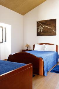 una camera con due letti e una coperta blu di Sicó In and Out a Penela