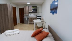 Cet appartement comprend une chambre avec un lit doté de deux oreillers et une cuisine. dans l'établissement AP138 3bDepartamento micro centro Parana 3b, à Paraná