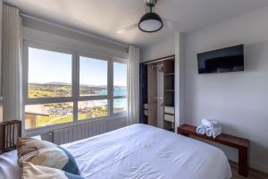 a bedroom with a bed and a large window at Primera línea de playa Surf & Beach in Sopelana