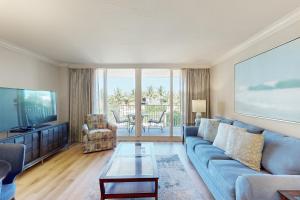 sala de estar con sofá azul y TV en Marco Beach Ocean Resort 601, en Marco Island