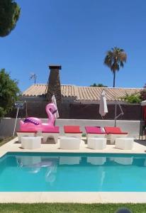 a pink flamingo float next to a swimming pool at Villa Amaya in El Puerto de Santa María