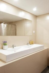 bagno con grande lavandino bianco e specchio di Sicó In and Out a Penela