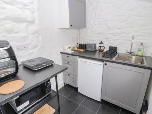 uma cozinha com um lavatório e uma bancada em Foxy Lady Cottage em Workington