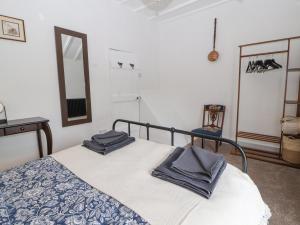 1 dormitorio con 1 cama con 2 toallas en Foxy Lady Cottage, en Workington