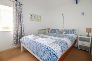 um quarto com uma cama com lençóis azuis e brancos em Moonlight em Truro