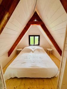 a bed in a attic with a window at House Of Harry - horská chata in Liberec