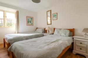 sypialnia z 2 łóżkami i stołem z lustrem w obiekcie Sunlight Cottage w mieście Truro