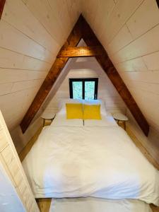 1 cama con 2 almohadas amarillas en el ático en House Of Harry - horská chata, en Liberec