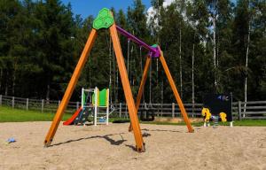 a playground with two swings in a park at Glamping Szelągówka in Sorkwity