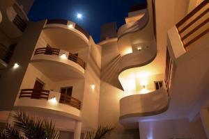 a large white building with balconies at night at aparthotelboavistacom in Sal Rei