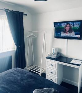 a bedroom with a bed and a tv on the wall at Idan House in Llanberis