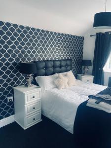 1 dormitorio con 1 cama grande y pared azul en Idan House, en Llanberis