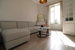 a living room with a couch and a table at Appartement 1er étage Cottage Reine in Cannes