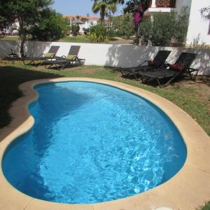 a large blue swimming pool with chairs in a yard at Tortuga Beach Resort 3 Bed Villa with pool in Santa Maria