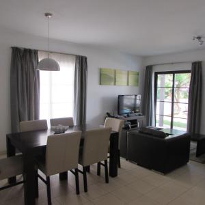 uma sala de estar com uma mesa de jantar e cadeiras em Tortuga Beach Resort 3 Bed Villa with pool em Santa Maria