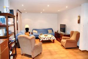een woonkamer met 2 stoelen en een blauwe bank bij 6 bedrooms villa with private pool furnished terrace and wifi at Cerezo de Mohernando in Cerezo de Mohernando