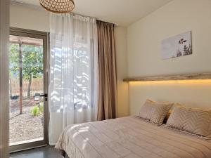 a bedroom with a bed and a sliding glass door at Miramonte Posada in Ciudad Lujan de Cuyo