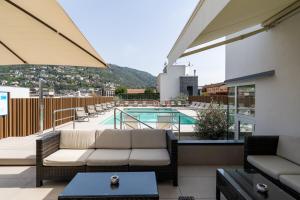 a balcony with a couch and a swimming pool at Hotel Como in Como