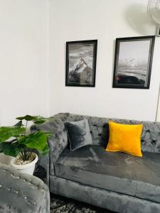 sala de estar con sofá gris y almohadas amarillas en Home Stays Juba, en Yuba