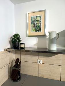 a shelf with a picture and a vase on it at Apartament Przebiśnieg in Polanica-Zdrój