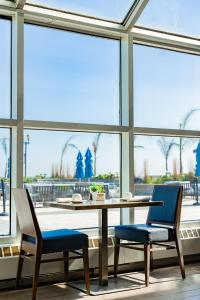 Ocean Place Resort & Spa في لونغ برانش: طاولة وكرسيين في غرفة بها نوافذ