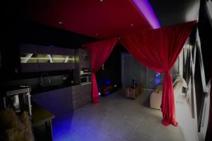 a kitchen with red curtains and a bathroom with a tub at L unique Cinéma Room in Grenoble