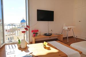 a living room with a flat screen tv on the wall at San Nikolas view guest house in Ermoupoli
