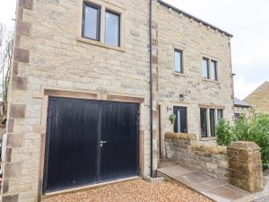 a brick house with a black garage door at 4 Lock View in Skipton