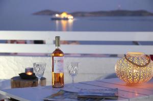 a bottle of wine sitting on a table with two glasses at San Nikolas view guest house in Ermoupoli