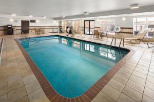 オマハにあるHoliday Inn Express Hotel & Suites Cherry Hills, an IHG Hotelのホテルの客室内の青い水の大きなプール