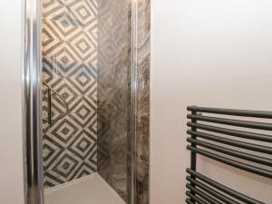 a shower in a bathroom with a tile wall at 4 Lock View in Skipton