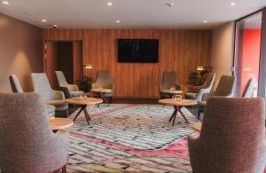 a waiting room with chairs and a flat screen tv at Pico Terramar & SPA in Areia Larga