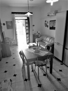 uma sala de estar com uma mesa e um sofá em villa poggiardo em Torre Lapillo