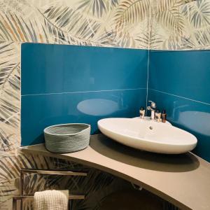 baño con lavabo y pared azul en Magica Ortigia, en Siracusa