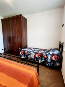 a bedroom with a couch and a wooden cabinet at la casa di simone in Torre Tre Ponti